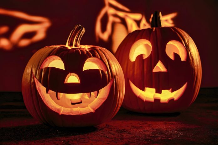 Halloween,Background.pumpkins,Carved,Into,Faces,,Standing,Prominently,Against,A,Dark