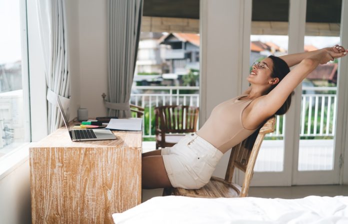 Freelancer,Woman,Stretches,At,Desk,With,Laptop,,Expressing,Physical,Reset,