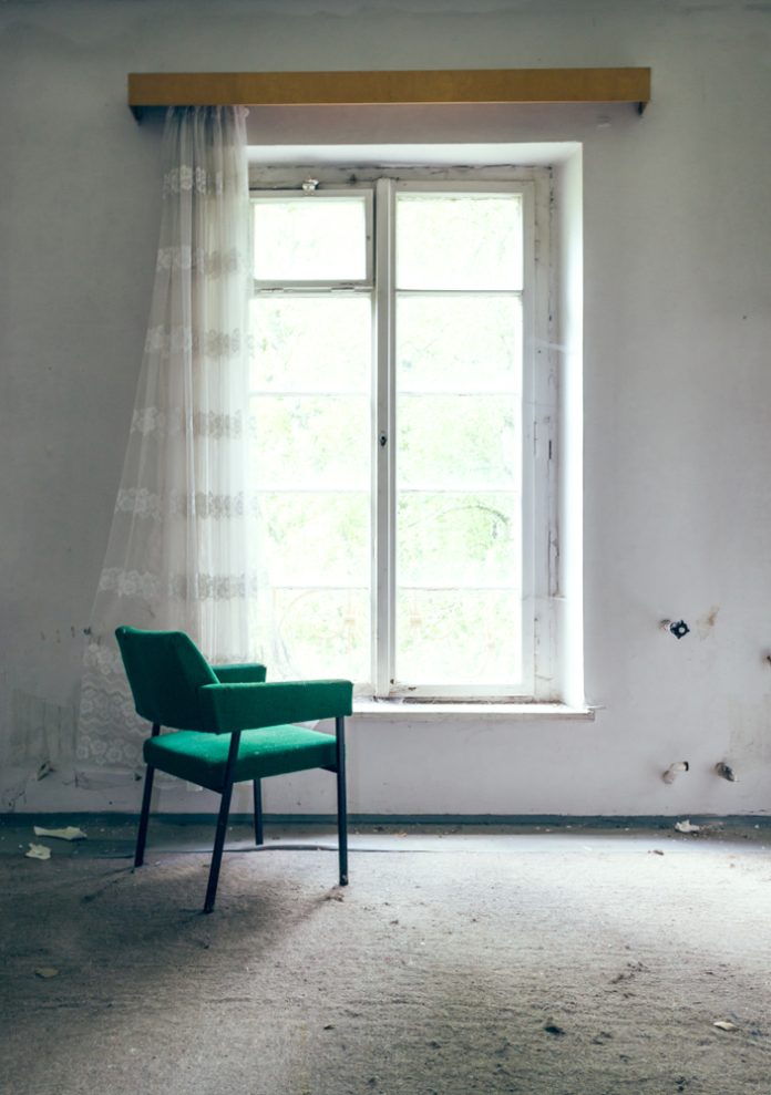 Green,Chair,By,The,Window,In,An,Abandoned,House