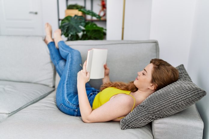 Young,Redhead,Girl,Smiling,Happy,Reading,Book,At,Home