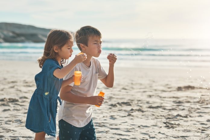 Travel,,Boy,And,Girl,With,Bubbles,By,Ocean,For,Playing,