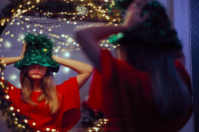 Woman,Trying,On,A,Christmas,Tree,Funny,Party,Hat,In