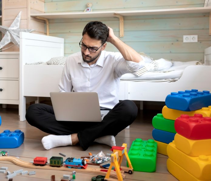 Young,Businessman,Playing,With,Kid's,Toys,In,The,Children's,Room.
