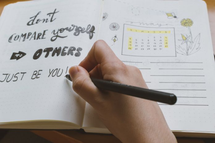 Female,Hand,Writing,In,A,Bullet,Journal,A,Self-esteem,Quote: