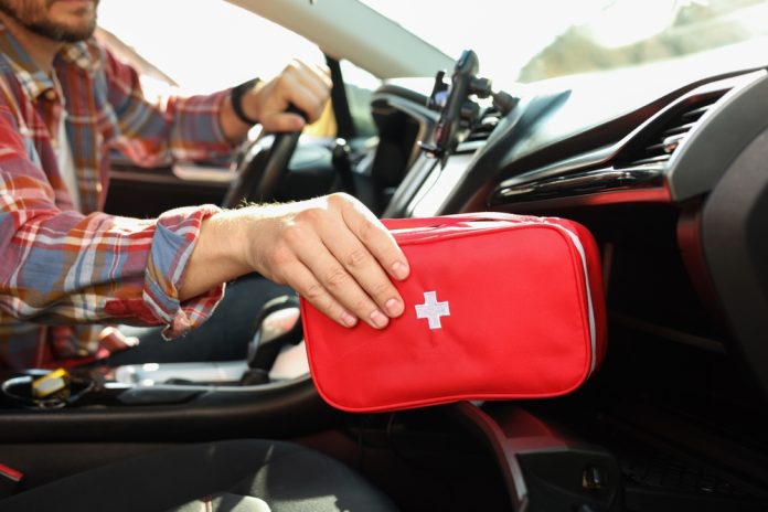 Man,With,First,Aid,Kit,Inside,Car,,Closeup