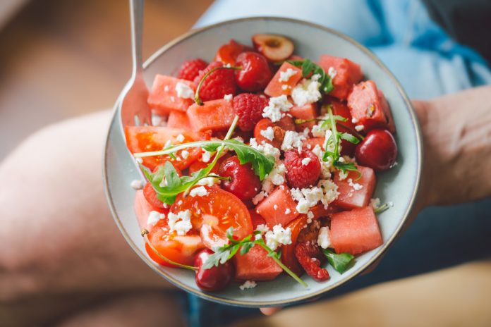 Young,Man,Holding,Fresh,Tasty,Summer,Salad,With,Fruits,,Berries