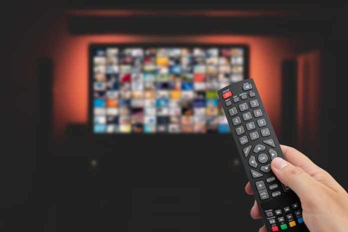 Video,On,Demand,,Tv,Streaming,,Multimedia.,Hand,Holding,Remote,Control