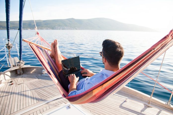 Working,In,Sea,Traveling.,Man,With,Laptop,In,Beach,Hammock.