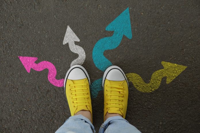 Woman,Standing,Near,Colorful,Arrows,Pointing,In,Different,Directions,On