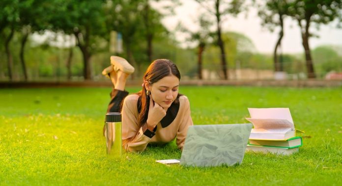 Indian,Young,Adult,Gen,Z,Student,Lying,On,Grass,Use