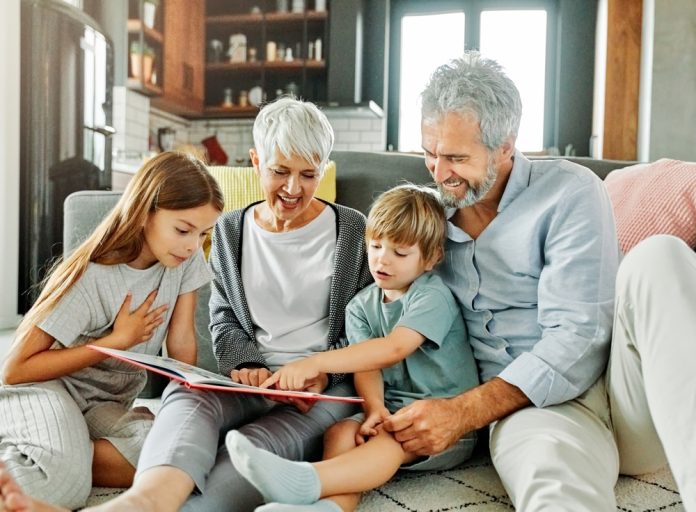 Portrait,Of,Grandparents,And,Grandchildren,Having,Fun,Together,Reading,A