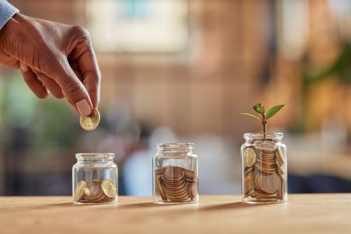 Close,Up,Of,Black,Woman,Hand,Adding,Money,In,Coin