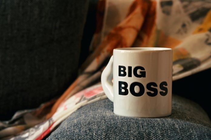 Big,Coffee,Cup,On,The,Rim,Of,Gray,Sofa