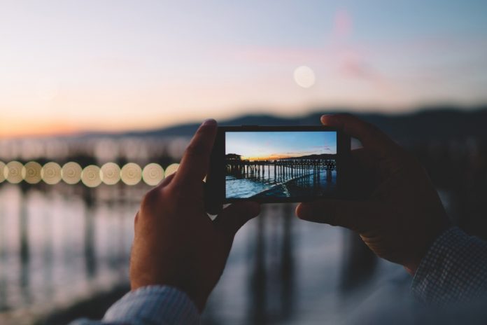 Cropped,Image,Of,Man,Taking,Photo,In,Evening,Dusk,Of
