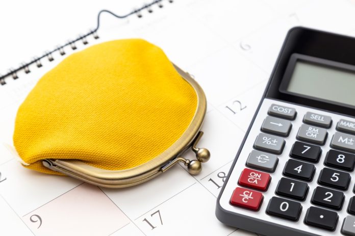 A,Calculator,And,A,Wallet,Placed,On,A,Calendar.