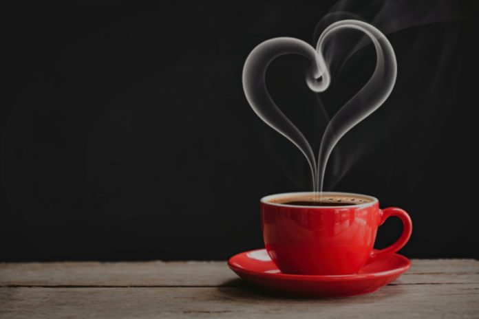 A,Steaming,Red,Coffee,Cup,On,A,Wooden,Surface,With