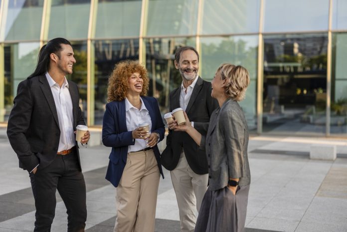 Diverse,Business,Professionals,Chat,And,Laugh,Outdoors,Over,Coffee,Cups,