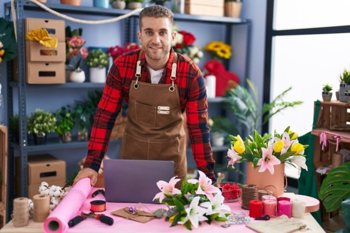 Young,Caucasian,Man,Florist,Smiling,Confident,Using,Laptop,At,Flower