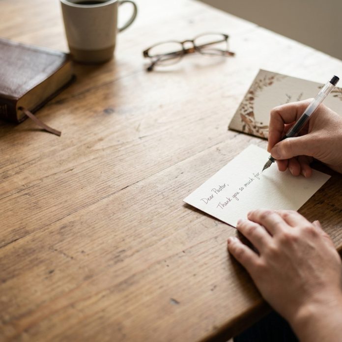 Close,Up,On,Table,,Hands,Writing,A,Thank,You,Note