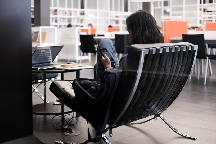 Playing,Smartphones,On,Chair,In,The,Library